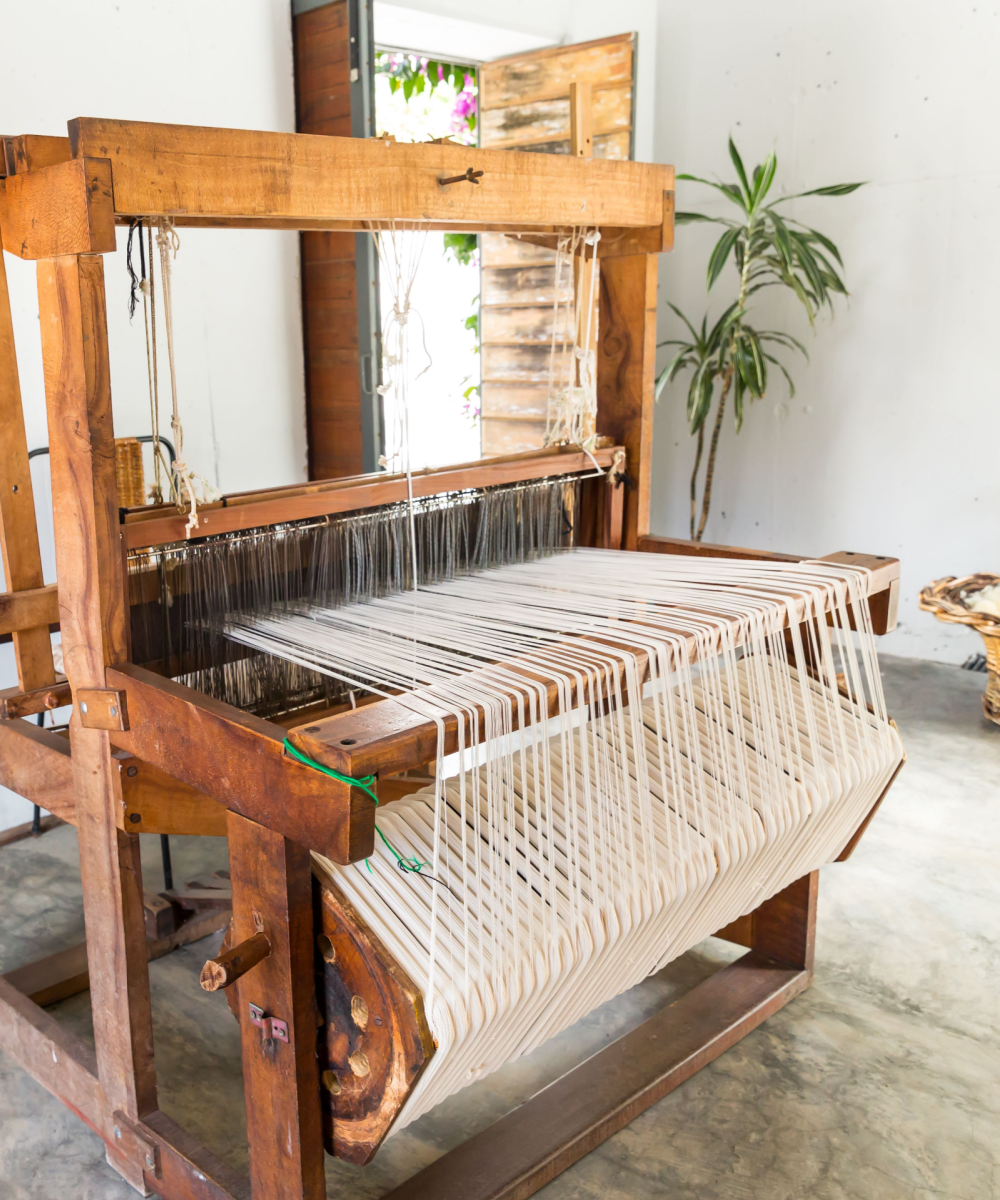 Ein hölzerner Webstuhl steht in einem Raum.